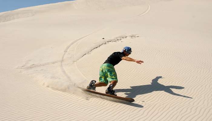 Sandboarding at the Red Sand Dunes for both novices and experts. 