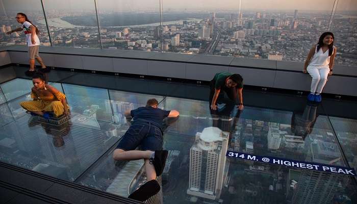 Thrilling glass tray experience at Mahanakhon SkyWalk overlooking Bangkok.