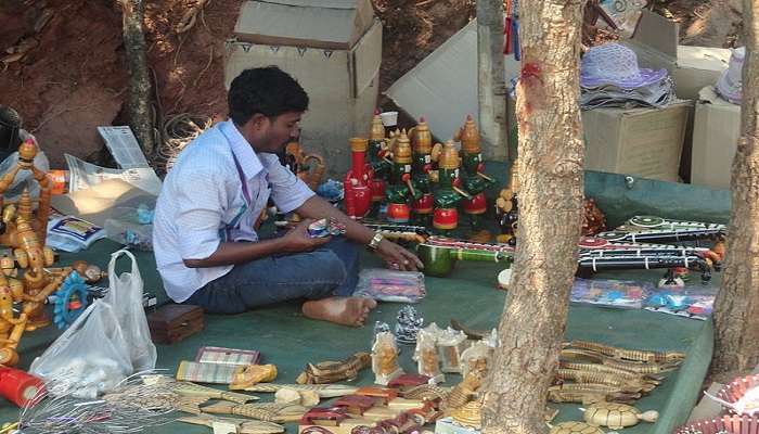 Person selling wooden artifacts at Lepakshi