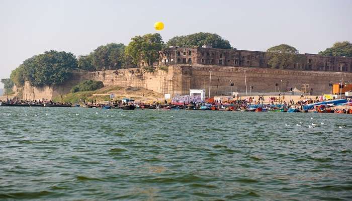 Image of the holy Yamuna River with colourful boats and tourists in the background