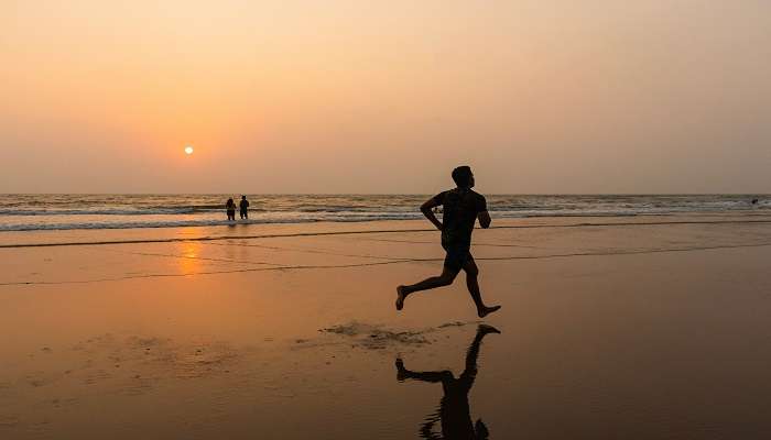 A person running along the beach early in the morning