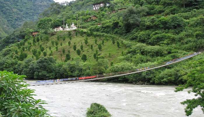  Suspension bridge over the river with a distant view of a monastery near Khoma