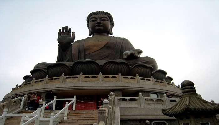 The image depicts the Tian Tan Buddha statue on Lantau Island