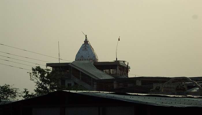 Chandi Devi Temple on Neel Parvat with devotees climbing the hill during winter.