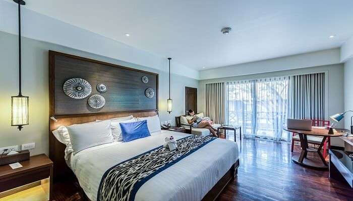 A white linen bed in a hotel room,one of the best Hotels in Vikasnagar