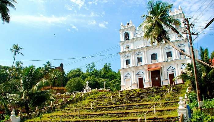 The captivating view of the Reis Magos Church adorned with lush greenery all around 