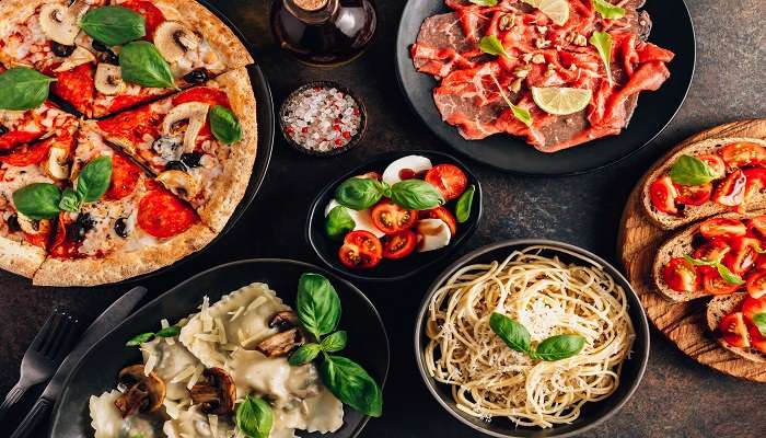 Full table of Italian meals on plates to taste at the wonderful restaurants near Agonda Beach.