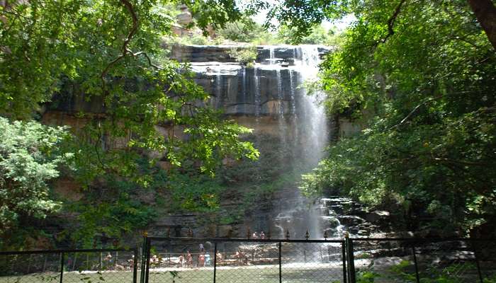  Serene Mallela Theertham Waterfall cascading into a clear pool, encircled by rocky terrain and dense green forest are wonderful places to visit in Nalgonda.
