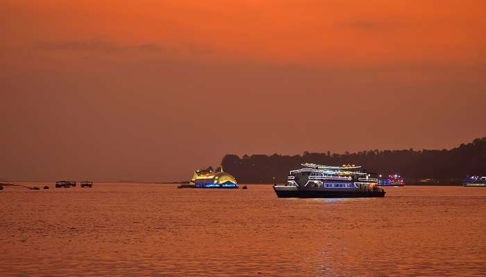 Casino ships sailing in Mandovi river in Goa during sunset to explore near Basilica of Bom Jesus church.