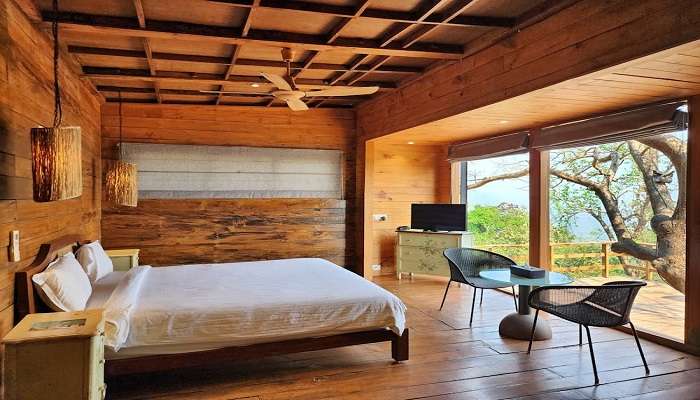A bedroom with an attached balcony in the cottage, near Devbagh beach