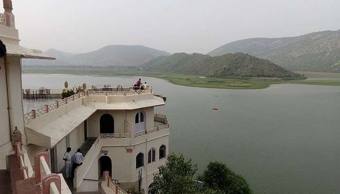 Mesmerising view of the silver lake with the lush green mountains in the background at neemrana fort palace. 