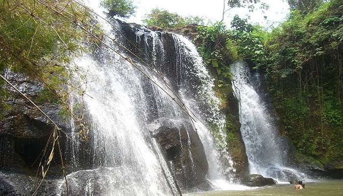 Katieng Waterfall in lush Asian jungle with smooth flowing water and serene, untouched nature.