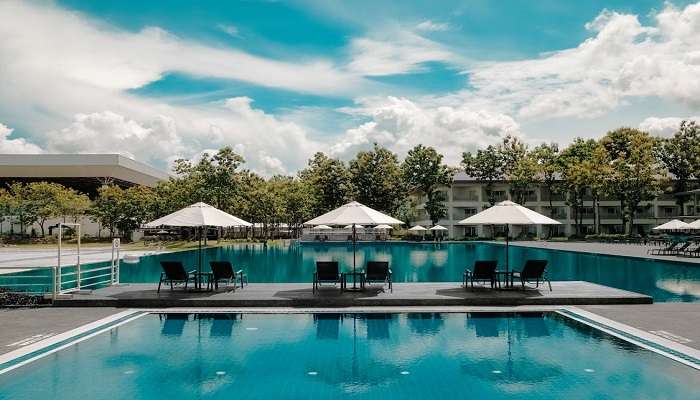 Black Outdoor Lounge Chair in Between Blue Swimming Pool Under White Cloudy Blue Sky, Hotels Near Krishnarajapuram