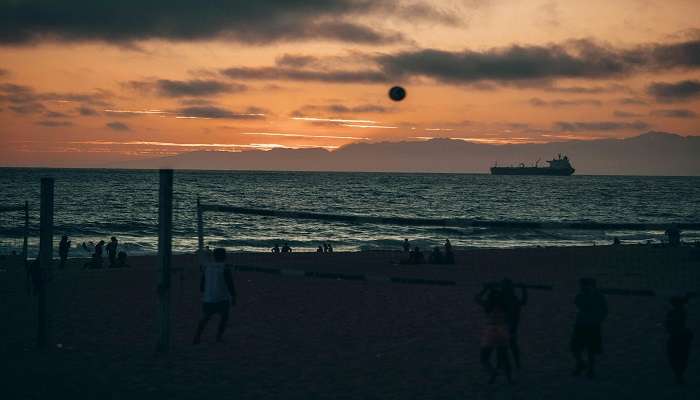 Some tourists play volleyball at Munakkal Beach.