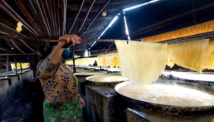 Local Vietnamese woman making rice paper