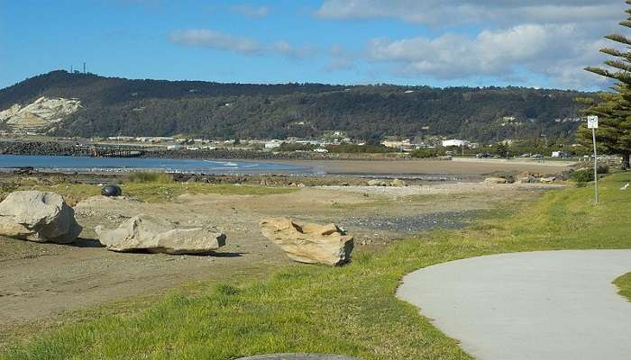 Scenic view of Burnie’s coastline with blue waters and lush green hills.