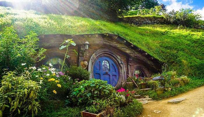 Some sightseers touring Hobbiton explore Hobbit holes and film sets in Matamata, New Zealand.