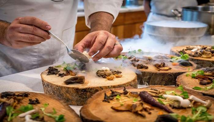 Chef in a restaurant serving a vegetable dish