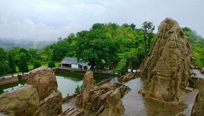 The picturesque landscape of Masrur in Himachal Pradesh, with lush greenery and distant mountains.