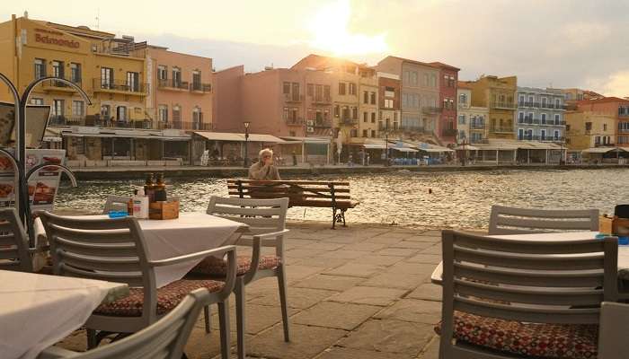 Outdoor tables near the sea in a coastal city on sunset