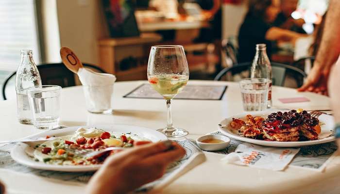 Wine in clear glass and food on table in a restaurant, restaurants in Wollongong