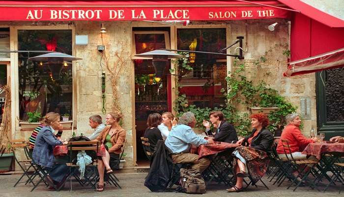 People Sitting Outside the Bistro while Having Conversation