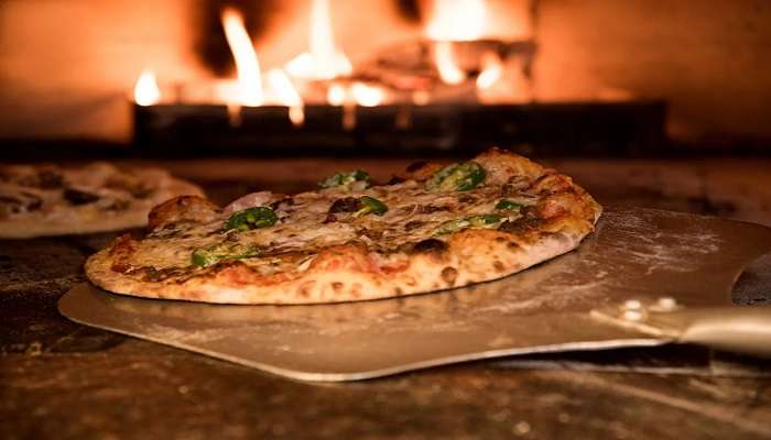 An image of pizza being baked in oven.