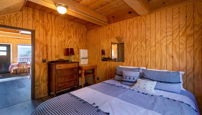 a hotel bedroom with a king-size bed and wooden interior