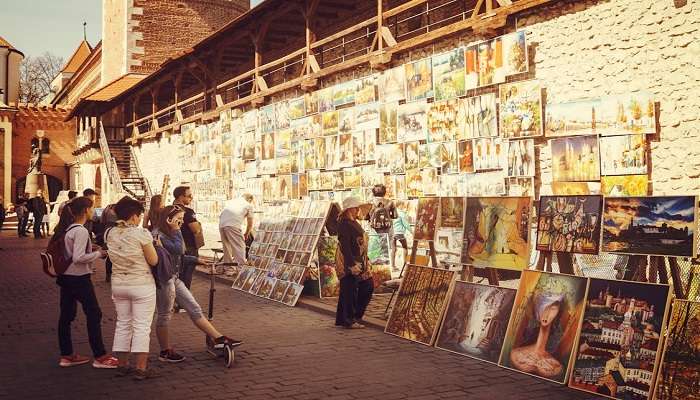 People viewing assorted paintings in a gallery