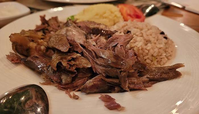 Freshly prepared Kuzu Tandir served in a restaurant.