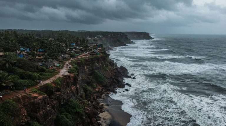 Aerial view of the Varkala cliff line and churning grey Arabian Sea under heavy monsoon clouds, Varkala, Kerala, India