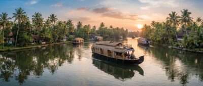 Kettuvallam houseboats cruising the palm-lined Alleppey backwaters at golden hour, Kerala itinerary