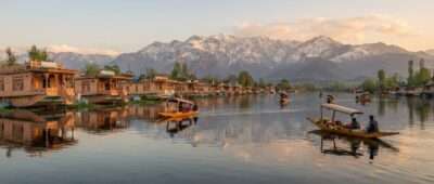 Shikaras and houseboats on Dal Lake with snow-capped peaks, Srinagar, Kashmir - why Kashmir is called heaven on earth